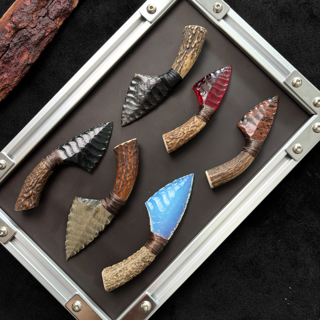 Assorted handcrafted knapped blades displayed together in different shapes and finishes
