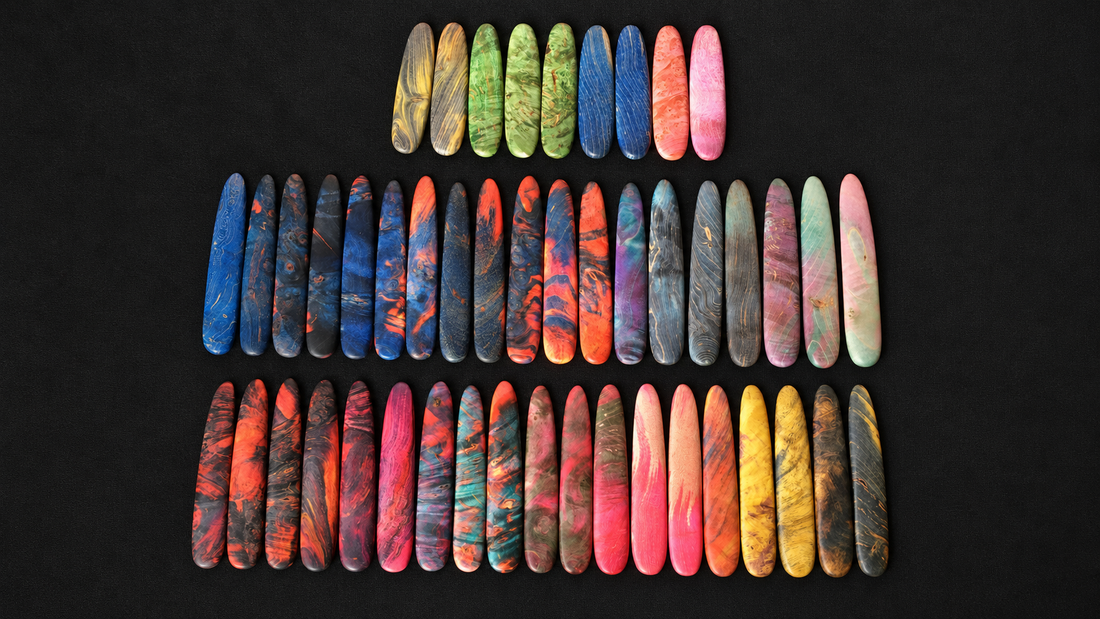 Colorful stabilized wood knife handle blanks arranged for handcrafted RELIQ display blades