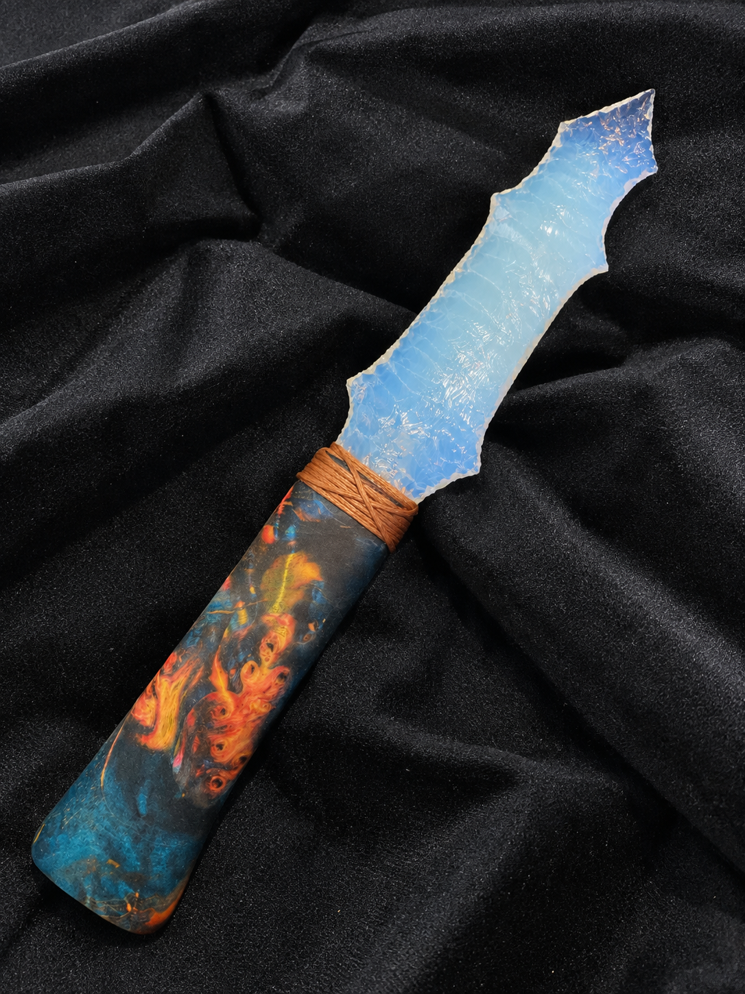 Blue opal-inspired display blade photographed on black fabric